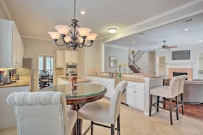 A spacious kitchen with a central island, white cabinetry, and a chandelier. - 4-BR Upscale Suburban Home with Private Pool (Plano)