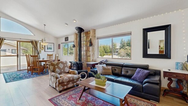 A spacious living room with a sofa, armchair, coffee table, and a fireplace. - Spacious home near town w/ private hot tub- next to trails & river (Ketchum)