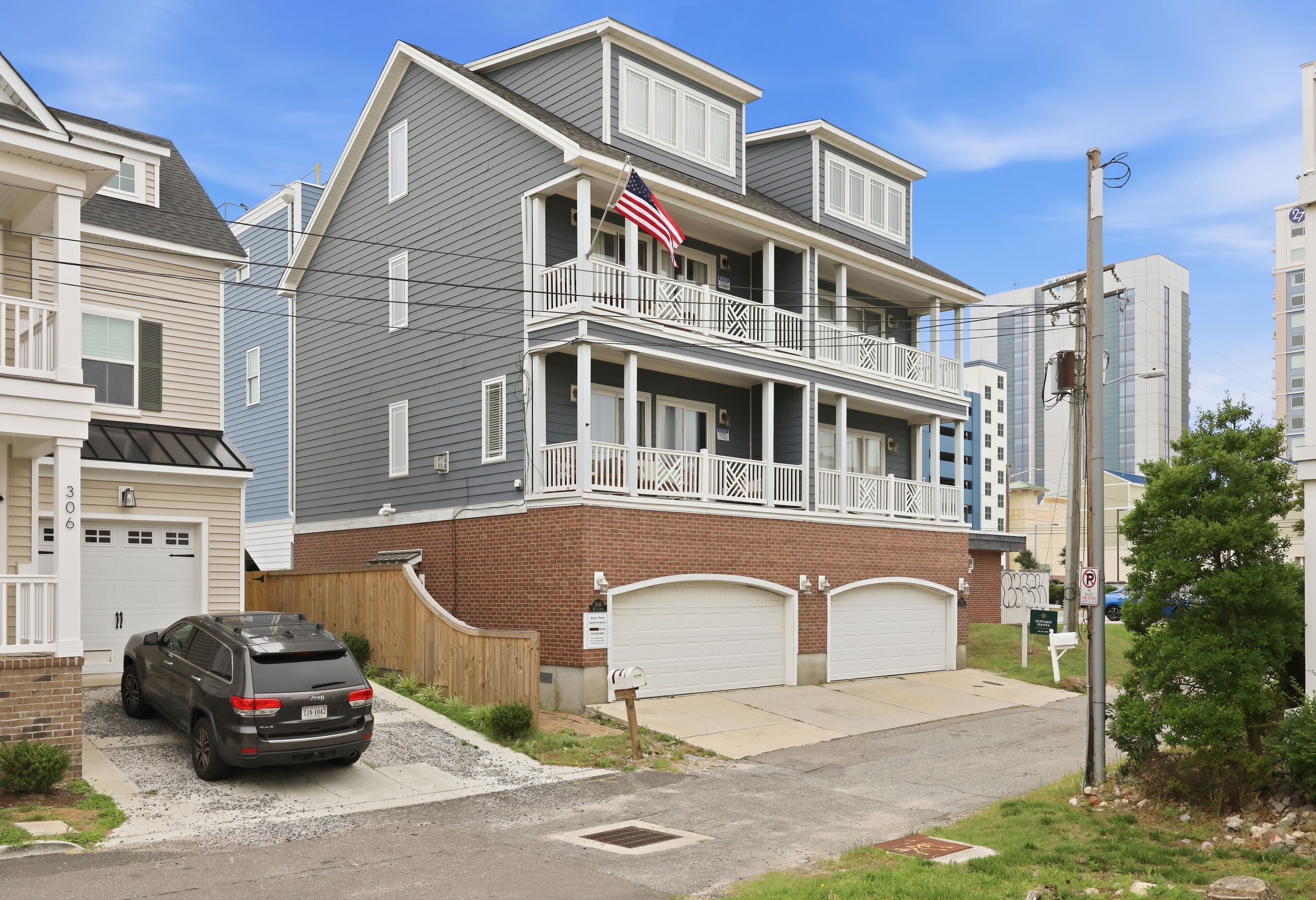 A two-story house with a balcony, a garage, and a driveway.