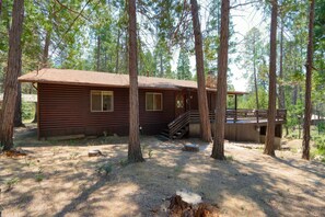 Une cabane avec une façade en bois, une véranda et un escalier menant à une terrasse.