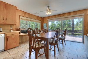 A wooden interior with a dining table, chairs, a ceiling fan, and large windows. - (37A) Alpine - The Redwoods in Yosemite (Yosemite National Park)