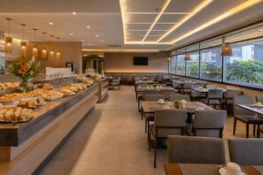 A modern dining area with a buffet, multiple tables, and a view of greenery outside. - Brazil CNPJ Test II - numeric (São Paulo)