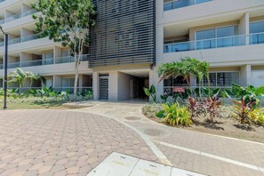 A modern building with a flat roof, multiple balconies, and a paved entrance area with plants. - Modern Beachfront Loft in Santa Marta (Santa Marta)
