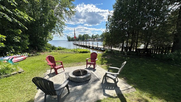 Takapihalla on nuotiopaikka, neljä Adirondack-tyylistä puutarhatuolia ja näkymä lahdelle, jossa on laituri.