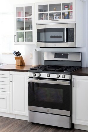 A kitchen with a stainless steel stove, oven, and microwave.