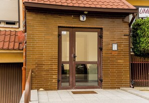 A brick building with a brown door and a small sign above it. - Piątkowska Homely Apartment (Poznań)