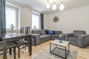 Ein modernes Wohnzimmer mit einer Eckcouch, einem Esstisch mit Stühlen und einem Couchtisch.