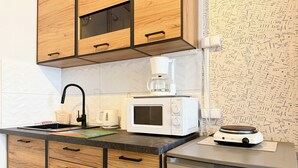 Una cucina con mobili in legno, un forno a microonde, una macchina da caffè e un’lavastoviglie.