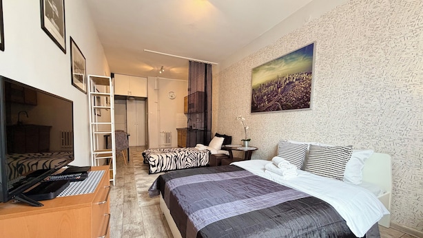 Una camera da letto con un letto, una scrivania, una sedia, un armadio e un bagno sullo sfondo.