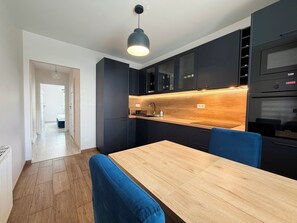 Een moderne keuken met donkere kastjes, een houten aanrechtblad en een ingebouwde oven.