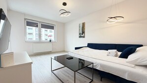 A modern bedroom with a bed, a desk, and a window. - Czartoryskiego Chic Apartment (Wrocław)