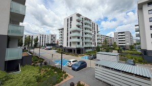 A modern apartment complex with multiple balconies, a parking area, and a small garden. - Czartoryskiego Chic Apartment (Wrocław)