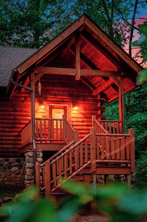 Eine Blockhütte mit Veranda und einer Treppe, die zum Eingang führt.