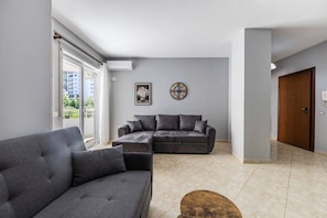Ein modernes Wohnzimmer mit einem Ecksofa, einem Couchtisch und einer Wanduhr.