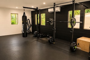 Ein Fitnessstudio mit Squat-Rack, Langhanteln und Gewichtsplatten.