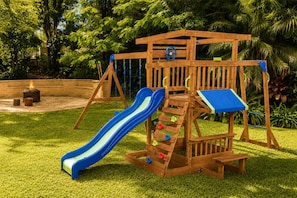 Ein Spielplatz aus Holz mit Rutsche und Klettergerüst.
