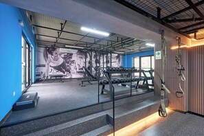 A gym with weightlifting equipment, a staircase, and a mural on the wall. - Miraflores via Larcomar / gym / Balcón Street and pool (Miraflores)