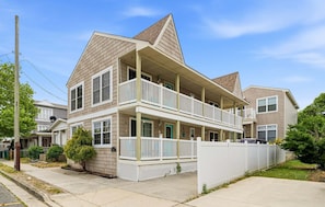 Ein zweistöckiges Wohnhaus mit Balkon, Veranda und Garage.