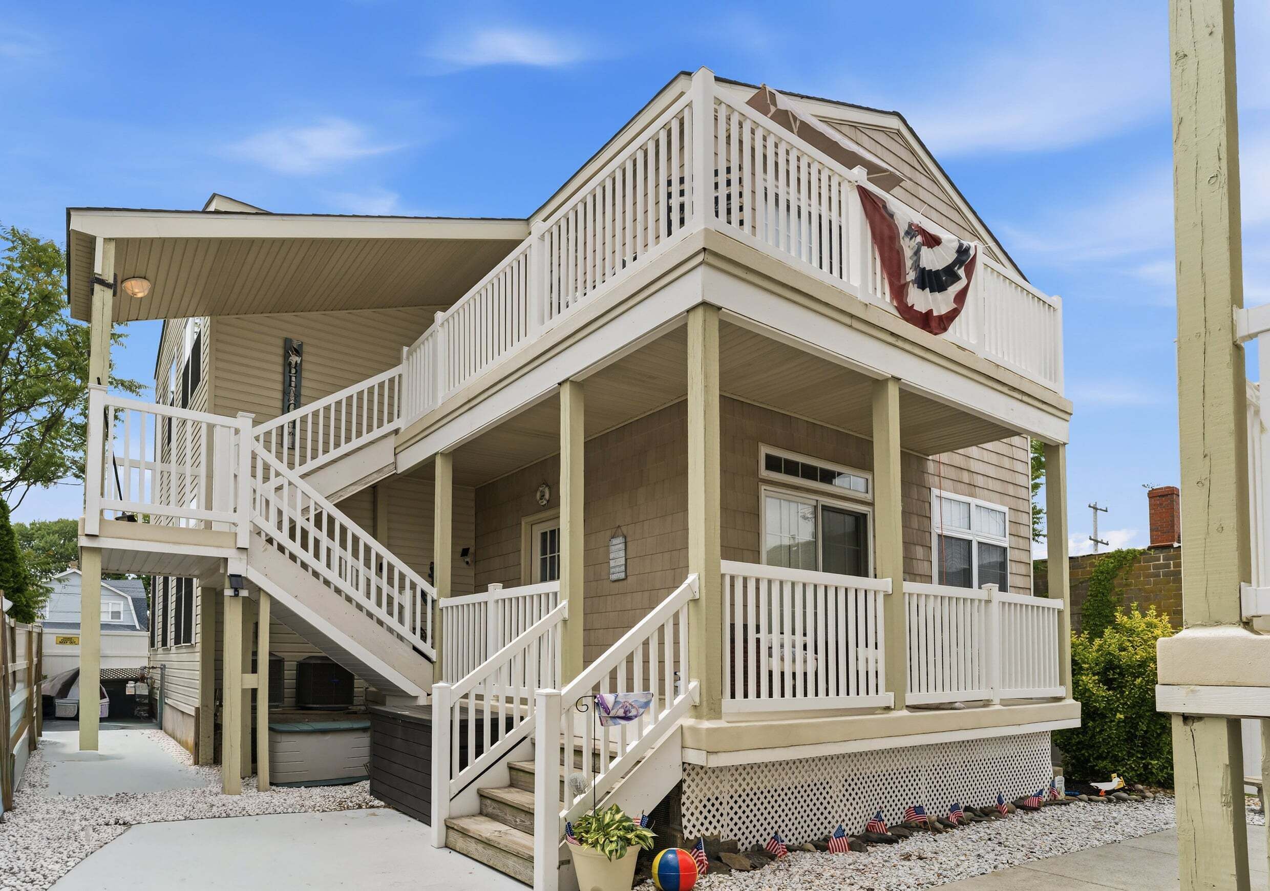 A two-story building with a balcony, a staircase, and a flag.