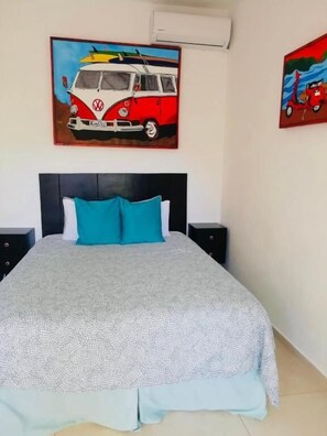Una cama con una colcha estampada, dos almohadas y un cabecero.