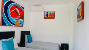 Un dormitorio con dos camas, una mesita de noche y decoración en la pared.