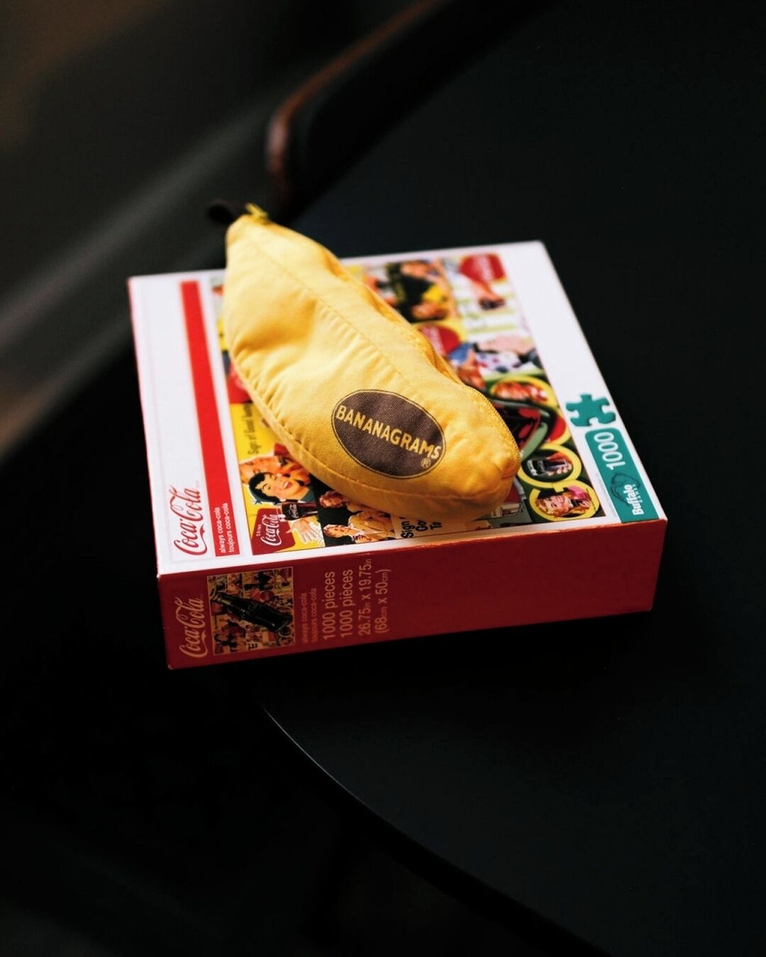 A box of Coca-Cola branded with a banana-shaped label, placed on a black surface.