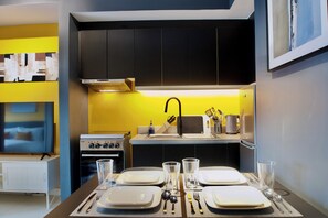 A compact kitchen with a microwave, stove, and sink.