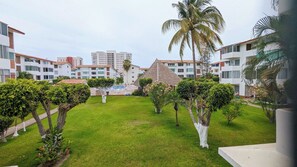 Ein Resort mit Pool, Palmen und modernen Gebäuden.
