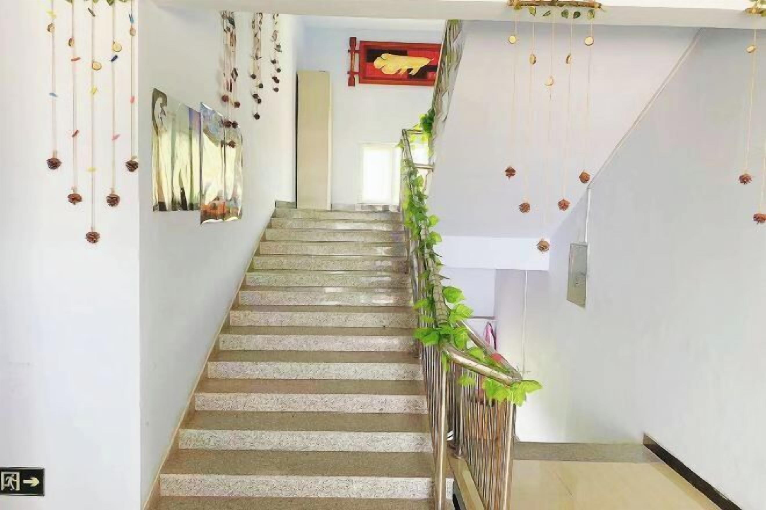 Una escalera con barandilla, decoraciones colgantes y un letrero rojo en la pared.