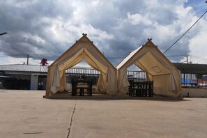 Una construcció amb teulada triangular i una porta central, envoltada per una tanca.