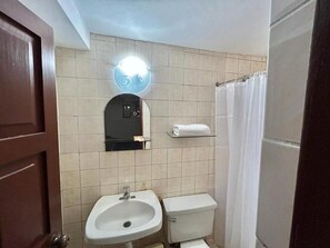 Een douche, handdoeken, zeep, toiletpapier