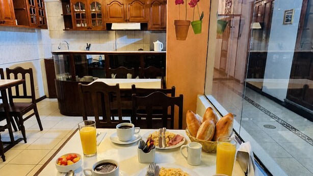 Una mesa de desayuno con diferentes platos, una taza de café y un vaso de jugo.