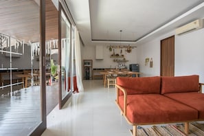 Una sala de estar moderna con sofá, comedor y cocina.