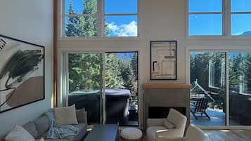 A spacious living room with a large window, a fireplace, and a view of the outdoors.