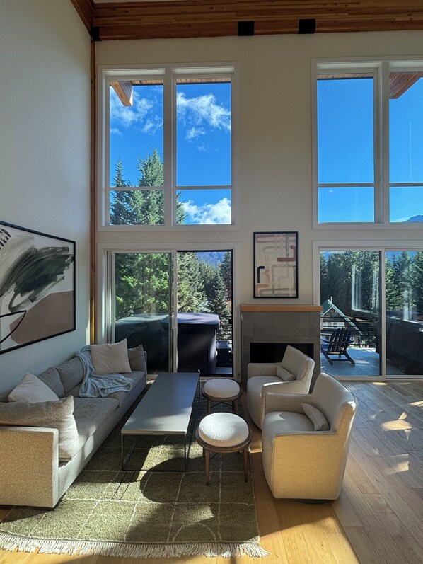 A spacious living room with a large window, a fireplace, and a view of the outdoors.