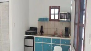 Eine kleine Küche mit Mikrowelle, Toaster und Spüle.