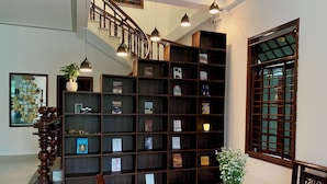 Ett bibliotek med bokhyllor, en trappa och ett stort fönster.