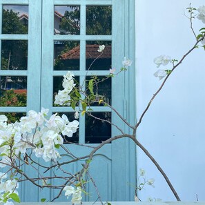 Ein Gebäude mit vielen Fenstern und ein Baum mit weißen Blüten davor.