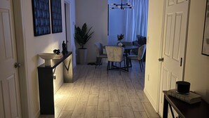 Cozinha moderna com área de refeições, piso de madeira e um vaso com planta.