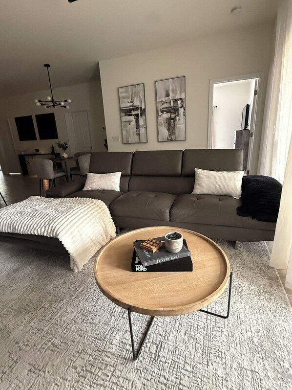 Una sala de estar moderna con un sofá, una mesa de centro y arte abstracto en la pared.
