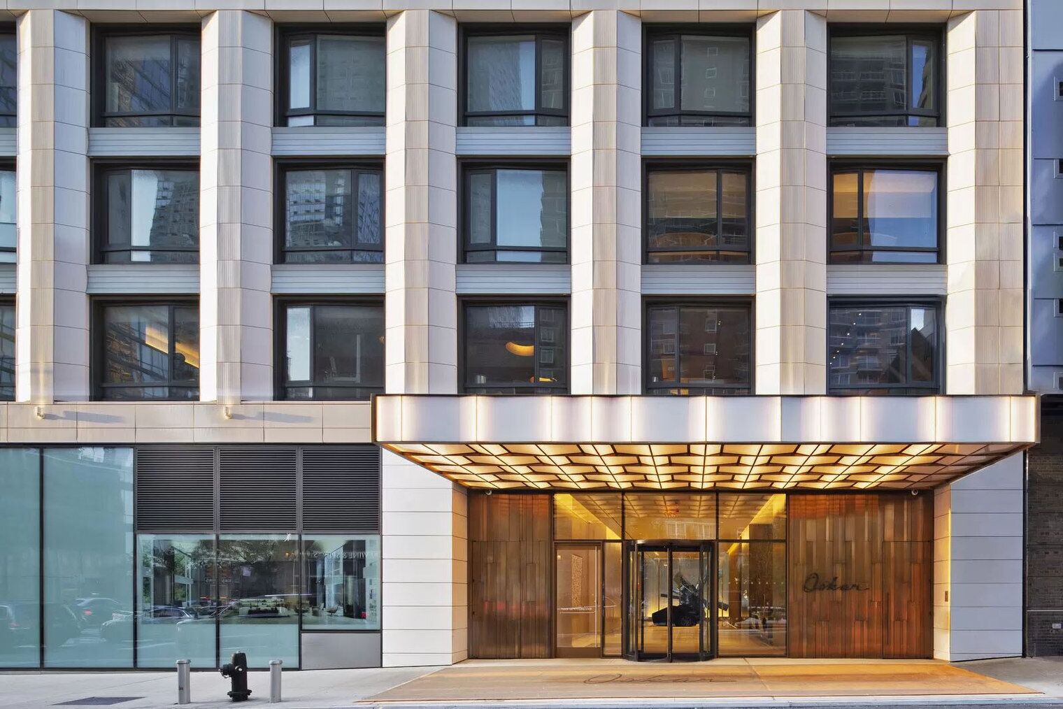 Un bâtiment moderne doté d’une entrée imposante, caractérisée par une façade en bois et une porte en verre.