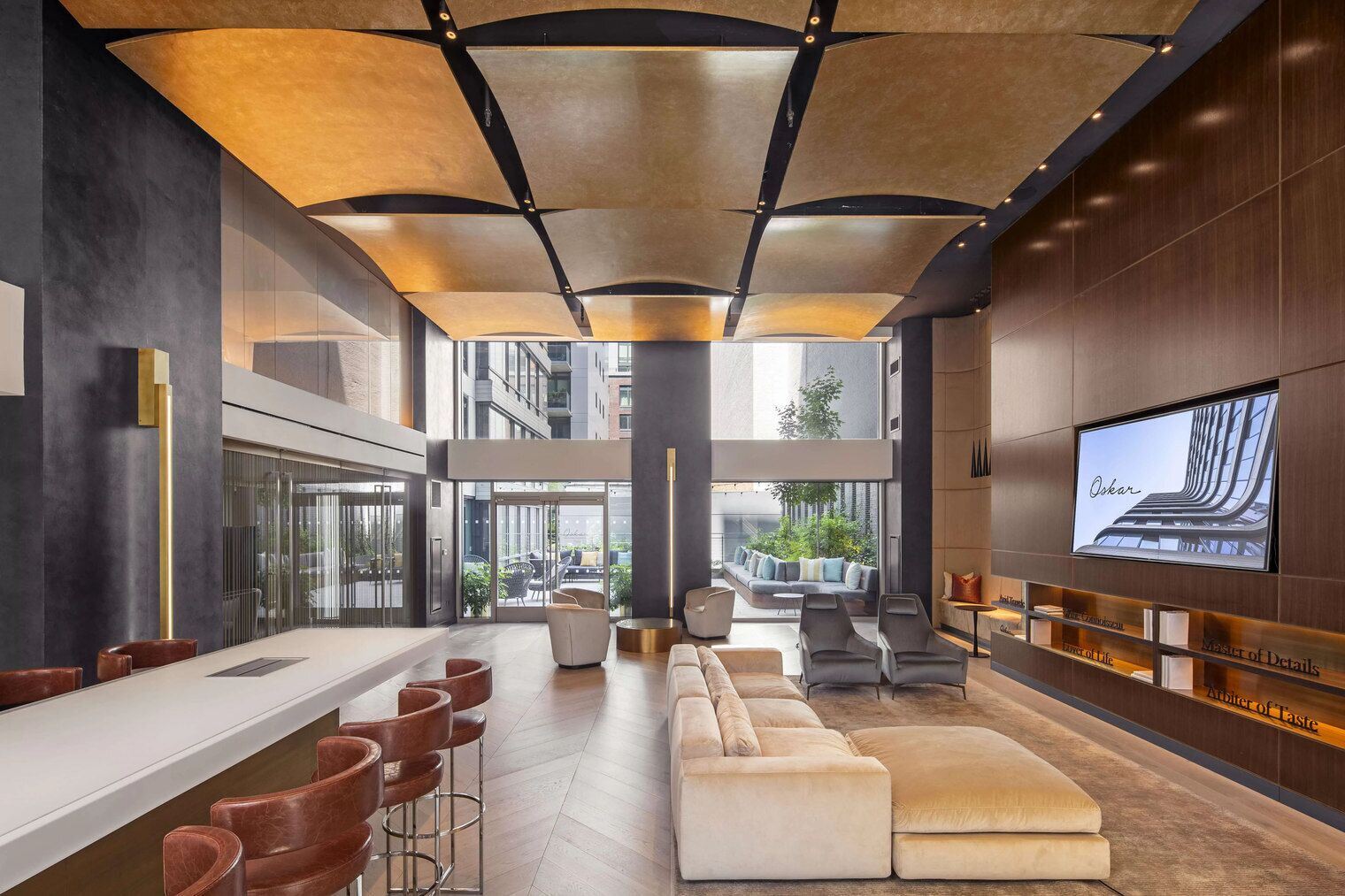 A modern interior with a bar area, seating, and a large TV screen displaying a building.