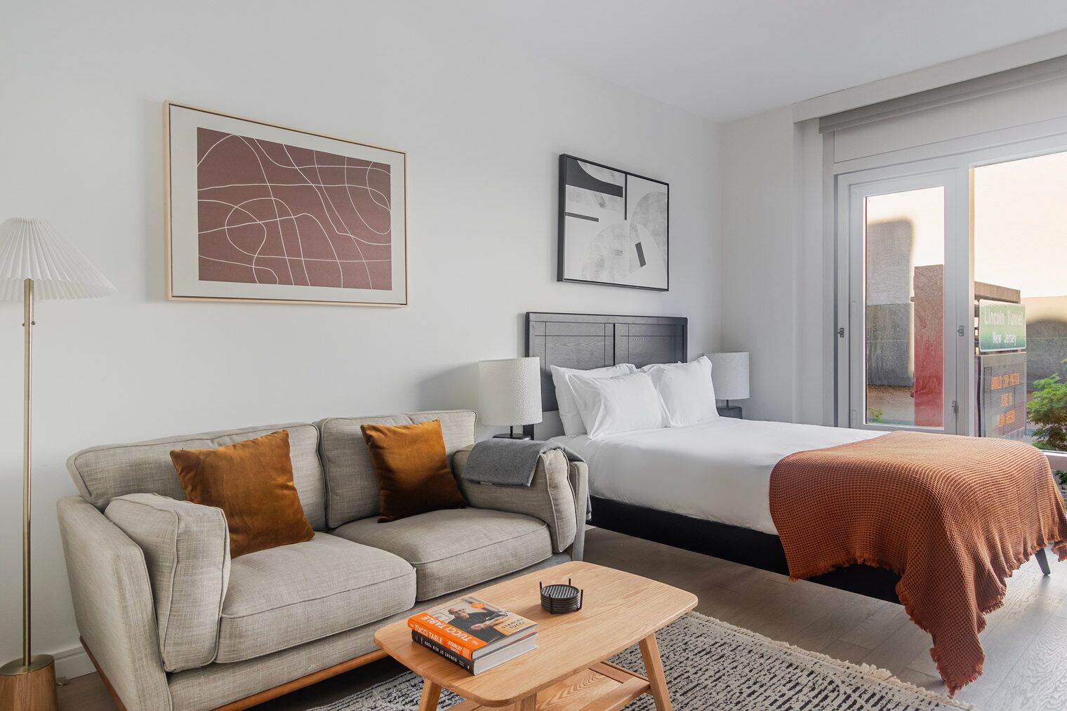 Ein Hotelzimmer mit einem Bett, einem Sofa, einem Couchtisch und zwei Wandlampen.
