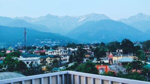 A town with buildings and mountains in the background. - Asian resort n farm  (Dharamshala)