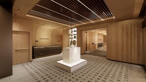En modern hotellobby med träpanel, en receptionsdisk och en central, vit skulptur.