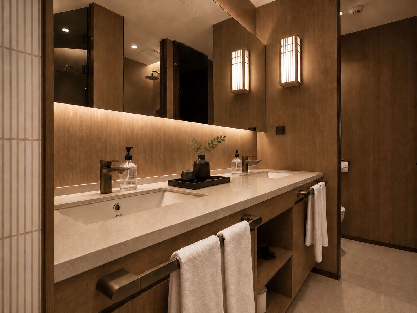 A modern bathroom with a large mirror, two sinks, and a towel rack.