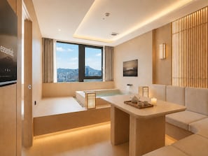 A modern hotel room with a large window, a bathtub, a sofa, and a television. - UH Continental SeoulCenter (Seoul)