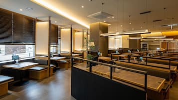 A modern restaurant interior with booths, tables, and a counter.