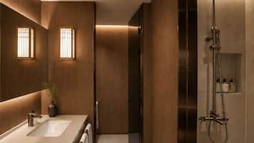 A modern bathroom with a large mirror, two sinks, a shower, and a potted plant.