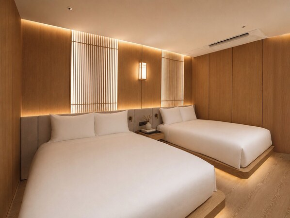 Una habitación de hotel moderna con dos camas, paneles de madera y una mesita de noche con un florero.